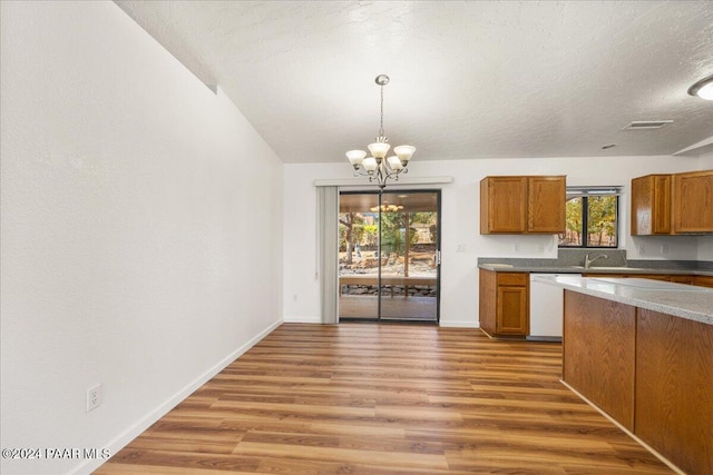 kitchen featuring a wealth of natural light, hardwood / wood-style floors, and white dishwasher