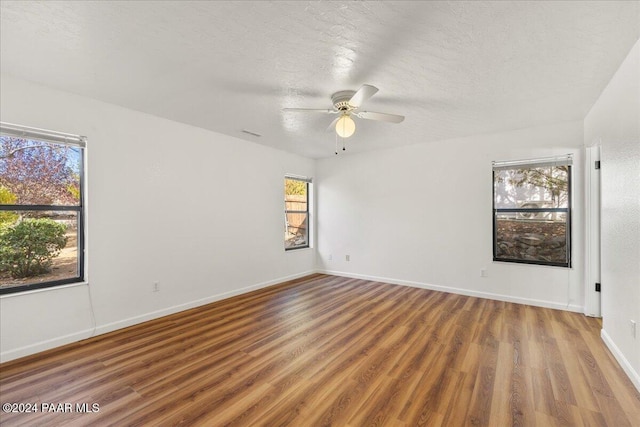 unfurnished room with ceiling fan, hardwood / wood-style floors, and a textured ceiling