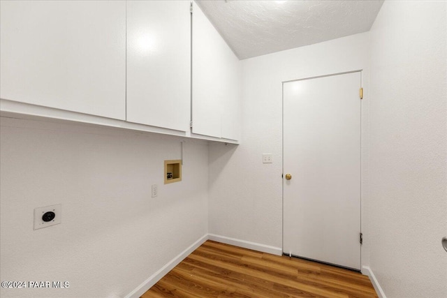 clothes washing area featuring cabinets, washer hookup, electric dryer hookup, hardwood / wood-style floors, and a textured ceiling