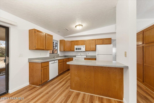 kitchen featuring white appliances, sink, light hardwood / wood-style flooring, vaulted ceiling, and a textured ceiling