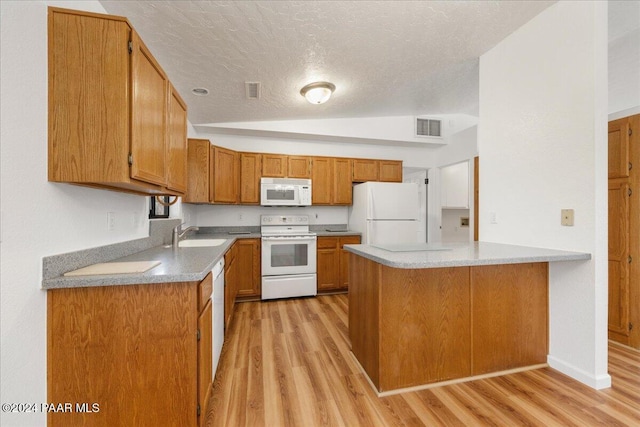 kitchen featuring white appliances, vaulted ceiling, light wood-type flooring, a textured ceiling, and kitchen peninsula