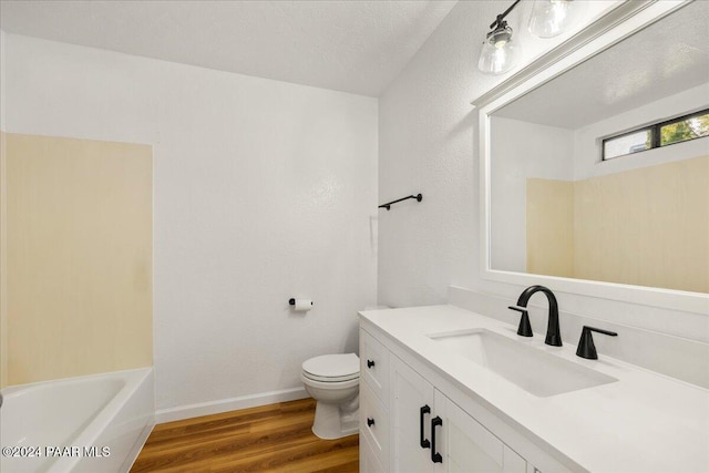 bathroom with vanity, hardwood / wood-style floors, a textured ceiling, and toilet