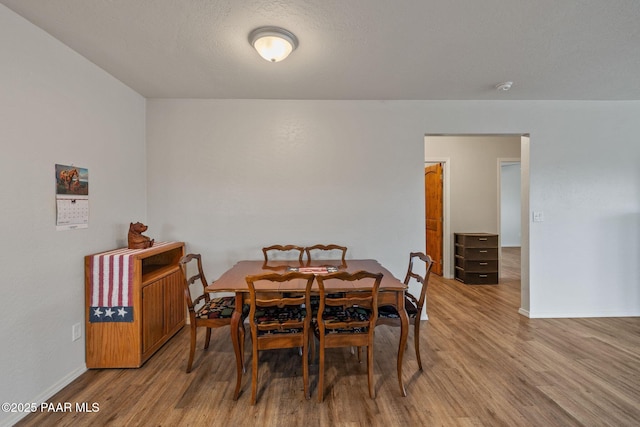 dining room featuring hardwood / wood-style floors and a textured ceiling