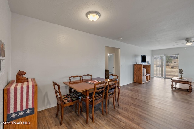 dining room featuring hardwood / wood-style flooring, ceiling fan, and a textured ceiling