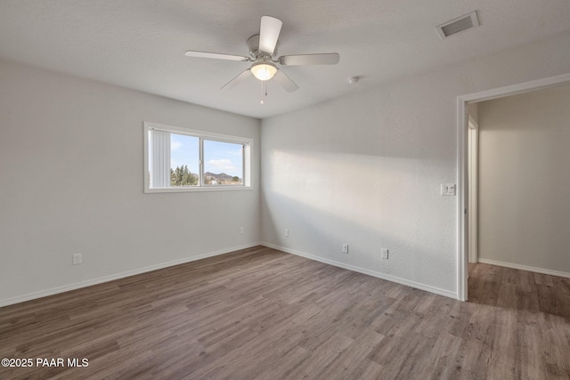 empty room featuring hardwood / wood-style floors and ceiling fan