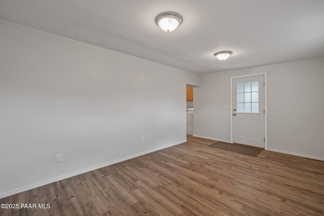 interior space with wood-type flooring, washer / clothes dryer, and a textured ceiling