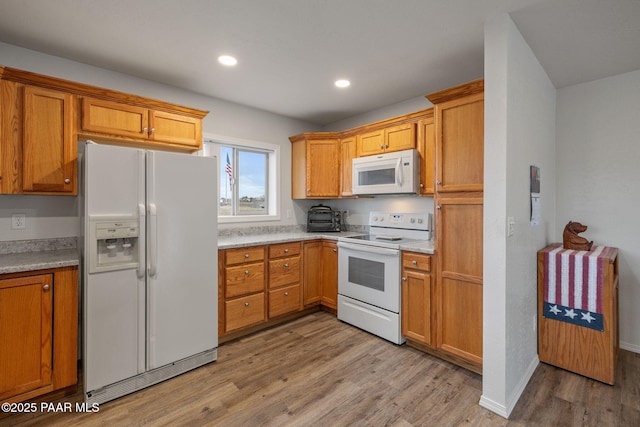 kitchen featuring white appliances and light hardwood / wood-style flooring