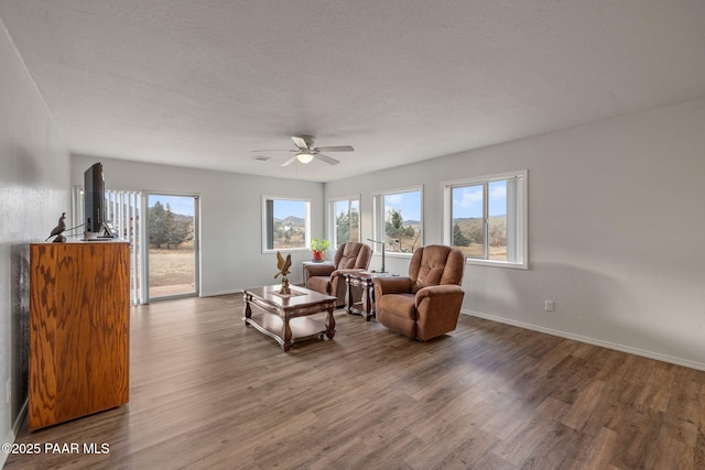 sitting room with ceiling fan, dark hardwood / wood-style floors, and a textured ceiling