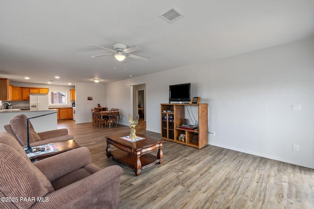 living room featuring ceiling fan and light wood-type flooring