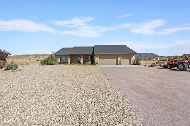 single story home featuring a mountain view and a garage