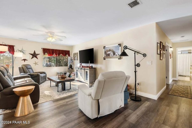 living room with ceiling fan and dark wood-type flooring