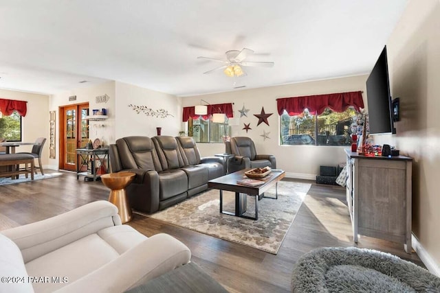 living room featuring ceiling fan and dark wood-type flooring