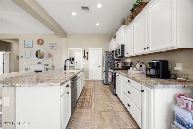 kitchen featuring sink, a center island with sink, white cabinets, and appliances with stainless steel finishes