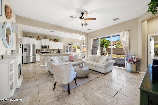 tiled living room featuring ceiling fan and sink