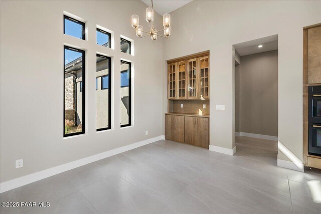 5285 High Cliff Way, Prescott, AZ 86301 - tiled empty room featuring a notable chandelier and a high ceiling