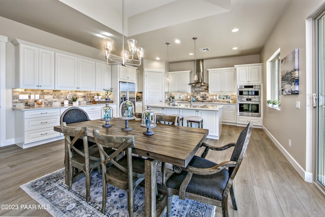 dining room with a notable chandelier and light hardwood / wood-style flooring