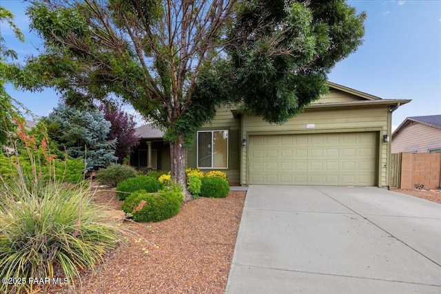 view of front of home with an attached garage, driveway, and fence