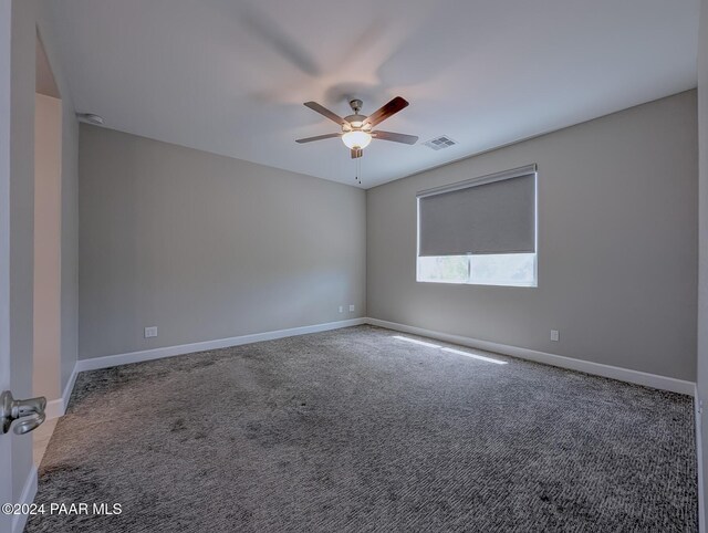 carpeted spare room featuring ceiling fan