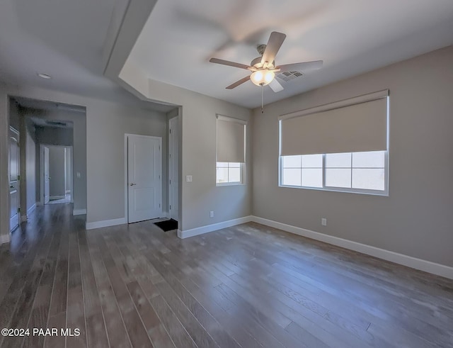 empty room with ceiling fan and dark hardwood / wood-style flooring