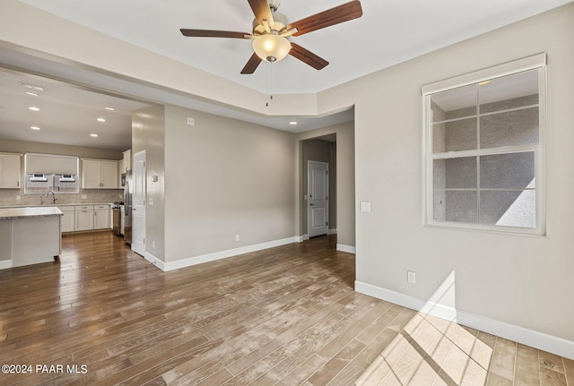 unfurnished living room with ceiling fan, light hardwood / wood-style flooring, and sink