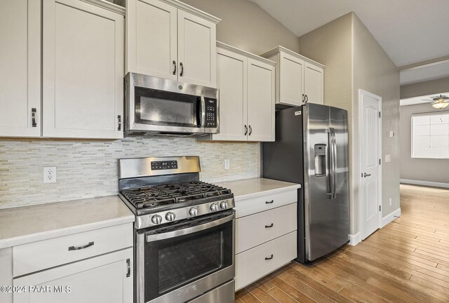 kitchen featuring ceiling fan, decorative backsplash, appliances with stainless steel finishes, light hardwood / wood-style floors, and white cabinetry