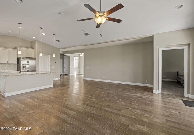 unfurnished living room featuring dark hardwood / wood-style floors, vaulted ceiling, and ceiling fan