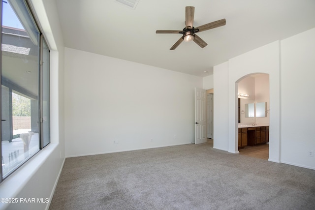 6560 E Brombil St, Prescott Valley, AZ 86314 - unfurnished bedroom featuring multiple windows, light carpet, arched walkways, and baseboards