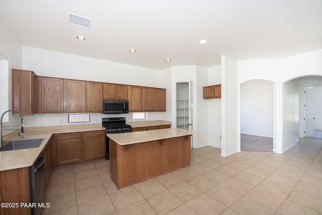 6560 E Brombil St, Prescott Valley, AZ 86314 - kitchen with a sink, range with gas stovetop, arched walkways, a center island, and light countertops