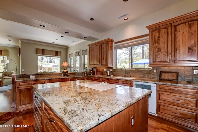 1021 Sheriffs Posse Trl, Prescott, AZ 86303 - kitchen with white appliances, light stone countertops, a peninsula, a kitchen island, and brown cabinets
