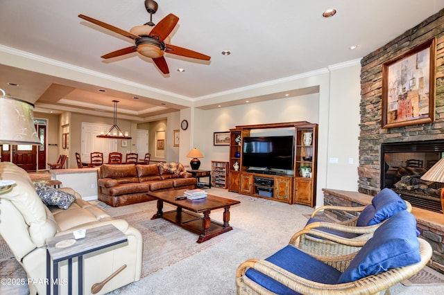 1021 Sheriffs Posse Trl, Prescott, AZ 86303 - carpeted living area featuring a ceiling fan, a stone fireplace, a raised ceiling, crown molding, and a chandelier
