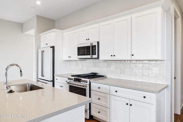 kitchen with white cabinetry, sink, backsplash, and white appliances