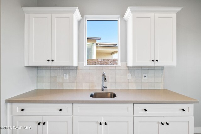 kitchen featuring sink, decorative backsplash, and white cabinets