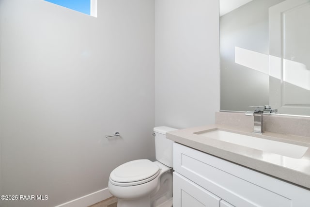 bathroom with hardwood / wood-style flooring, vanity, and toilet