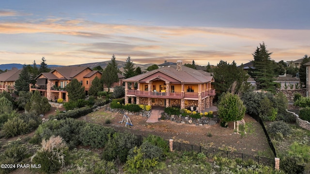 back house at dusk with a balcony