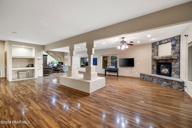 unfurnished living room featuring a fireplace, hardwood / wood-style floors, built in features, and ceiling fan