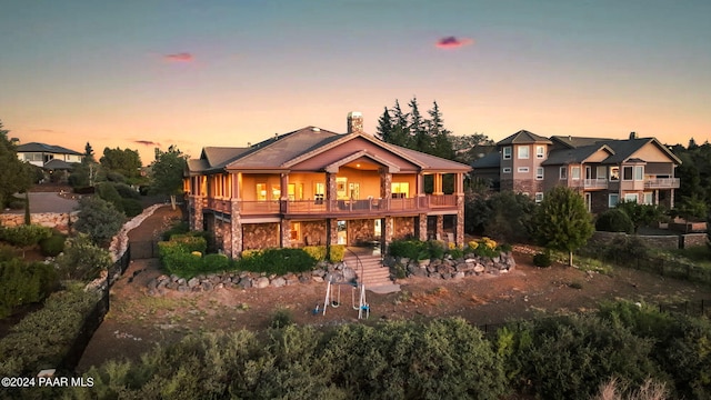 back house at dusk with a balcony