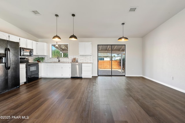 kitchen with tasteful backsplash, a healthy amount of sunlight, black appliances, pendant lighting, and white cabinets