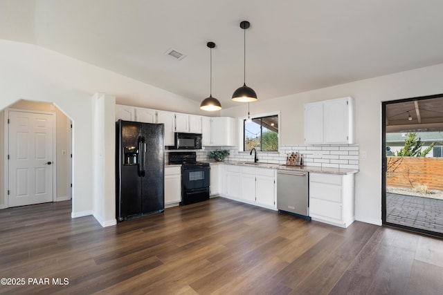 kitchen featuring white cabinetry, vaulted ceiling, hanging light fixtures, and black appliances