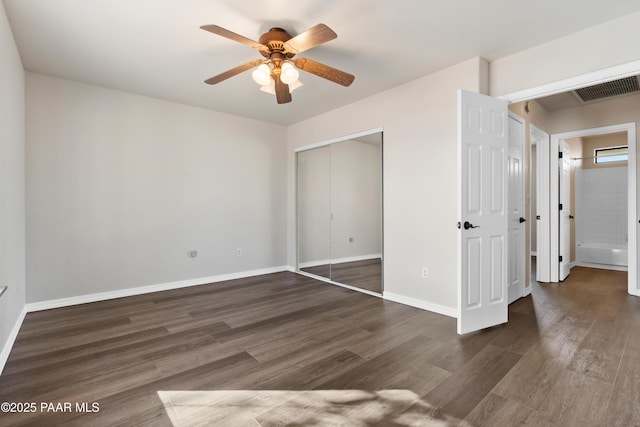 unfurnished bedroom featuring ceiling fan, dark wood-type flooring, and a closet