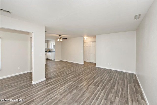 unfurnished living room with dark wood-type flooring and ceiling fan