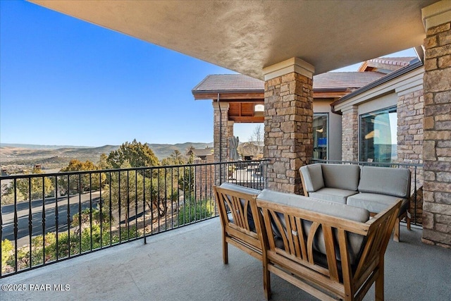 balcony with an outdoor living space and a mountain view