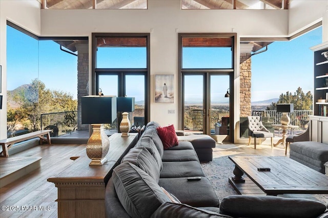 living room with a mountain view, hardwood / wood-style floors, and wooden ceiling