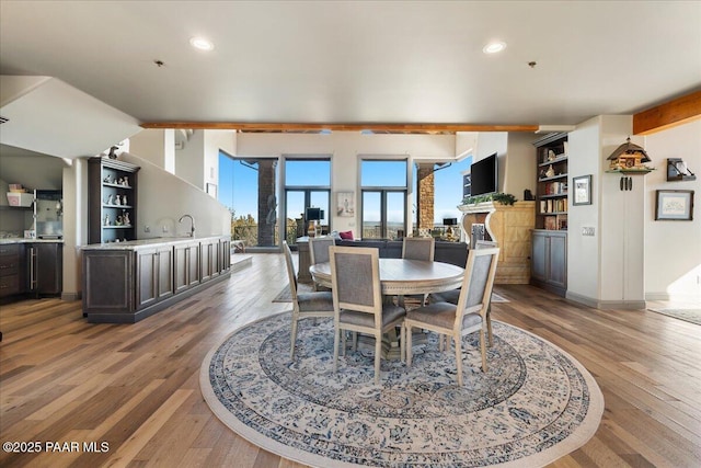 dining room with a fireplace, sink, and light hardwood / wood-style flooring