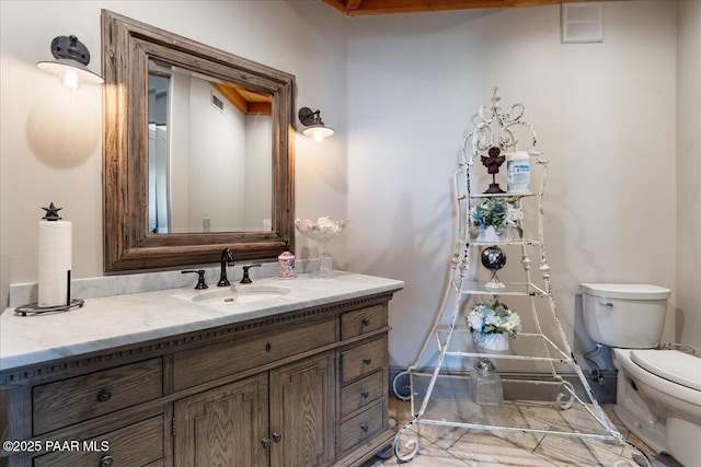 bathroom featuring vanity and toilet