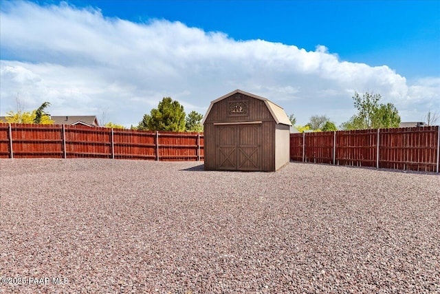 view of yard with an outbuilding, a fenced backyard, and a storage unit
