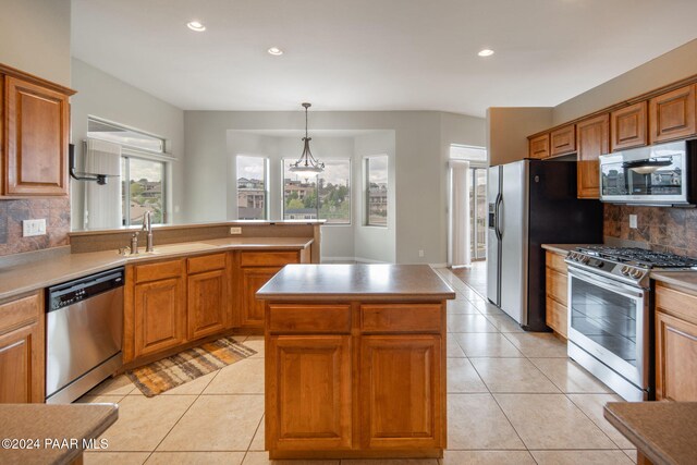 kitchen featuring backsplash, a kitchen island, sink, and stainless steel appliances