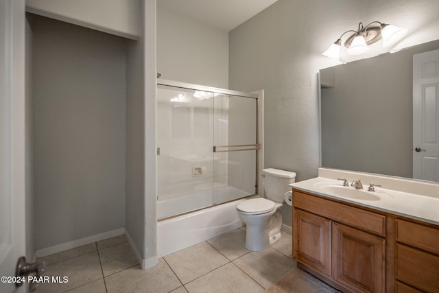 full bathroom with tile patterned flooring, vanity, toilet, and bath / shower combo with glass door