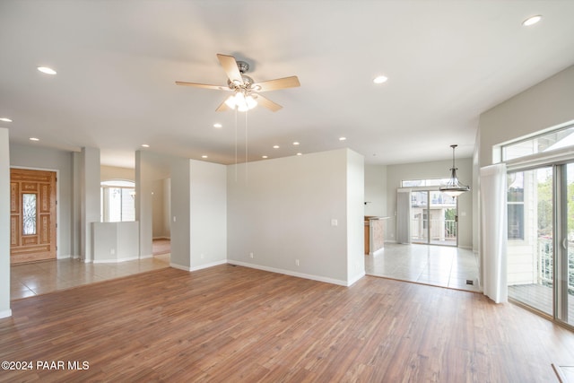 spare room featuring light wood-type flooring, plenty of natural light, and ceiling fan