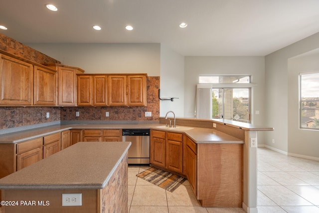 kitchen with sink, a kitchen island, stainless steel dishwasher, and light tile patterned floors