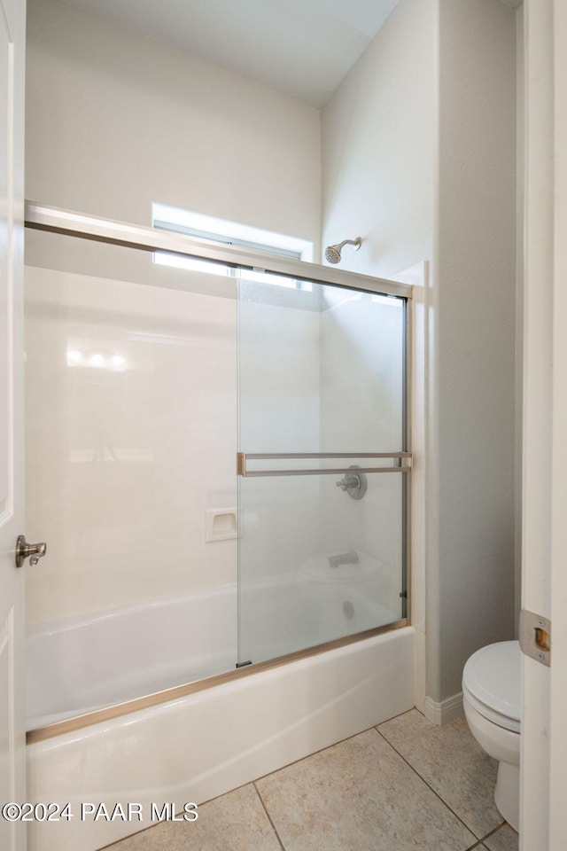 bathroom featuring tile patterned floors, toilet, and enclosed tub / shower combo